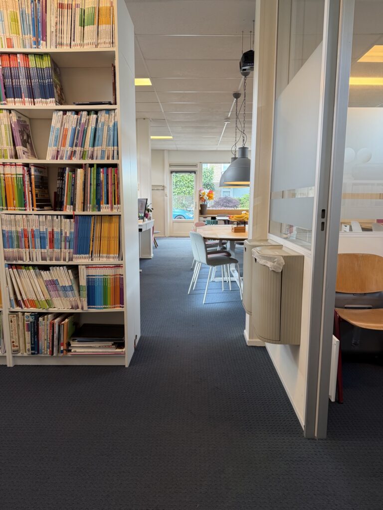 Kast met lesmethodes, met doorkijk naar de werktafel